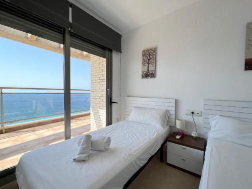 カルプにあるBahia del Sol Atico en Calpe con impresionantes vistas.のベッドルーム(白いベッド1台、大きな窓付)