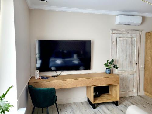 a room with a desk with a television on a wall at Villa Blue Mare in Ustronie Morskie
