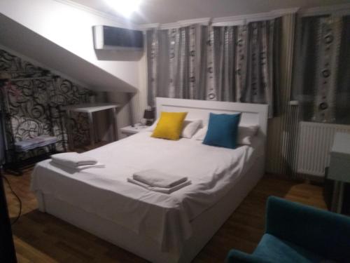 a bedroom with a large white bed with colorful pillows at Old Capital in Mtskheta