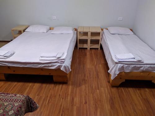 two beds in a room with wooden floors at Old Halidzor in Halidzor