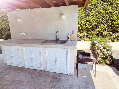 a outdoor kitchen with a sink and a counter at Villa14 Sea Breeze in Khlorakas