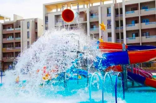 a water slide in a pool with a ball in it at قرية جراند هيلز in ‘Izbat Nādī aş Şayd