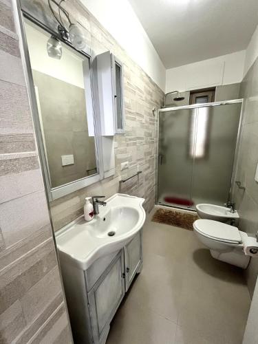 a white bathroom with a sink and a toilet at Le Stanze di Lucia vicino Ospedale Cardinale Panico a Tricase in Tricase