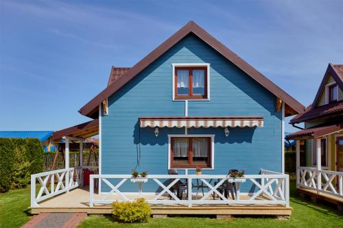 a blue house with a table in front of it at Morska Mila in Gąski