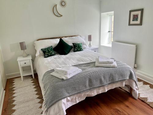 1 dormitorio con 1 cama con toallas en Little Withens, en Haworth