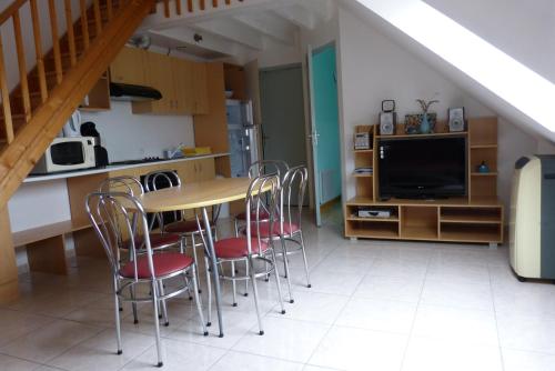 a kitchen and dining room with a table and chairs at Residence des Ondines in Damgan