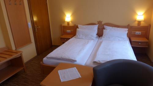 ein kleines Hotelzimmer mit 2 Betten und einem Tisch in der Unterkunft Central-Hotel Greiveldinger in Perl