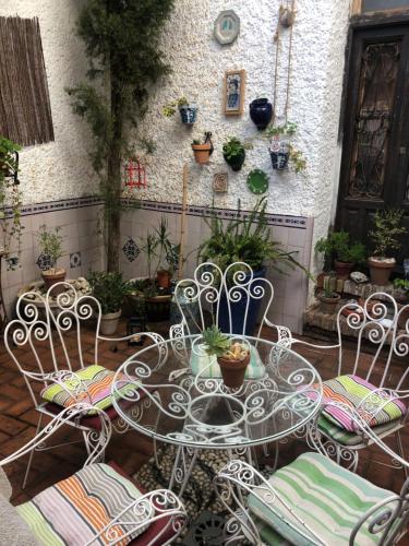a patio with a table and chairs and plants at Alhambra en el Sacromonte in Granada