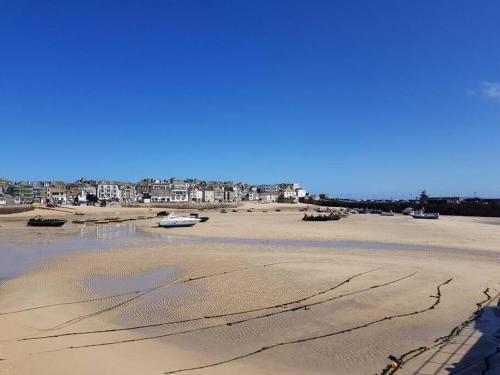 a beach with boats in the sand and houses at High quality detached house with parking St. Ives in St Ives