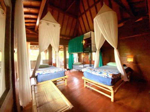 a bedroom with three beds in a room at Ubud Rice Field House in Ubud