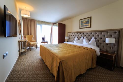 ヴィーナスにあるCarmen International Hotel Venus - Fost Becali Hotelの大型ベッドとテレビが備わるホテルルームです。