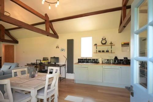 cocina y sala de estar con mesa y sillas en Beautiful 2 bed cottage picturesque tranquil setting en Sywell