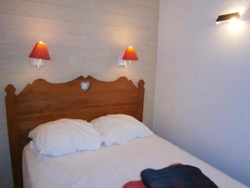 une chambre avec un lit avec deux oreillers et deux lampes dans l'établissement Appartement confortable à Le Dévoluy 28 m² avec vue montagne, à Saint-Étienne-en-Dévoluy