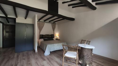 a bedroom with a bed and a table and a chair at La Posada de la Xana in Llanuces