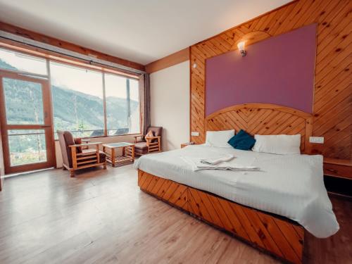 1 dormitorio con 1 cama grande y escritorio en Cafe Monkbase- Food and Stay, en Manali