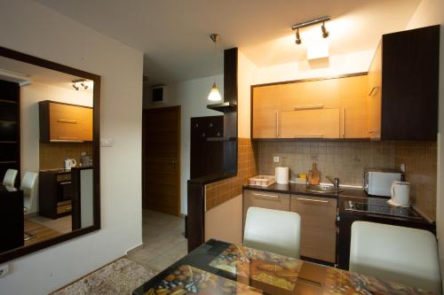 a kitchen with wooden cabinets and a table with chairs at Apartment 204 in Kopaonik