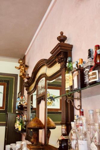 a room with a mirror and a shelf with bottles at Art Hotel Pandos in Tabiano