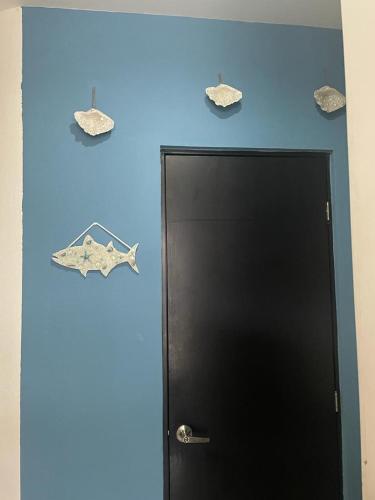a door with two fish on a blue wall at Casa Diamante Azul in Manzanillo