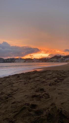 a beach with the sun setting in the background at Casa Diamante Azul in Manzanillo