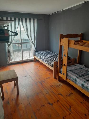 1 Schlafzimmer mit 2 Etagenbetten und einem Fenster in der Unterkunft Parivaar Host in Concepción del Uruguay