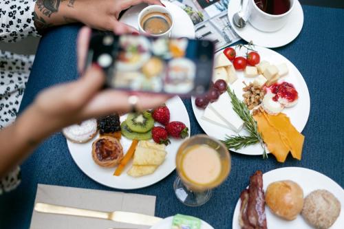 a person taking a picture of a table of food at Casual Raízes Porto in Porto