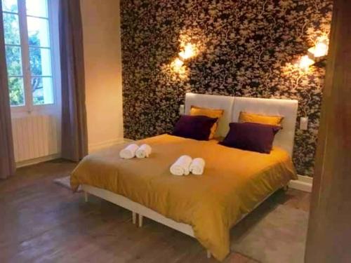 a bedroom with a bed with two towels on it at Les Croque-Notes, chambres et table d'hôtes in Lorignac