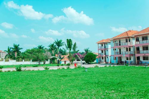 a green yard in front of a building at Hotel Santa Maria in Arua