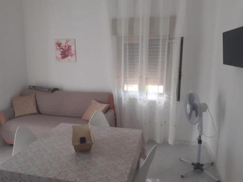 a living room with a table and a couch at Case vacanza Belvedere in Realmonte