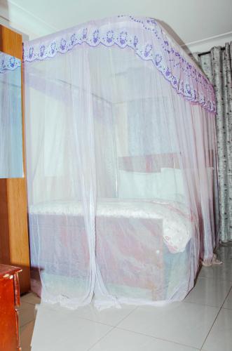 a bed with a canopy in a room at Hotel Santa Maria in Arua