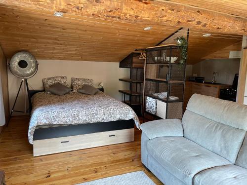 - une chambre avec un lit et un canapé dans l'établissement Sublime studio de caractère ,50 m2 climatisé ., à Montlaur-en-Diois