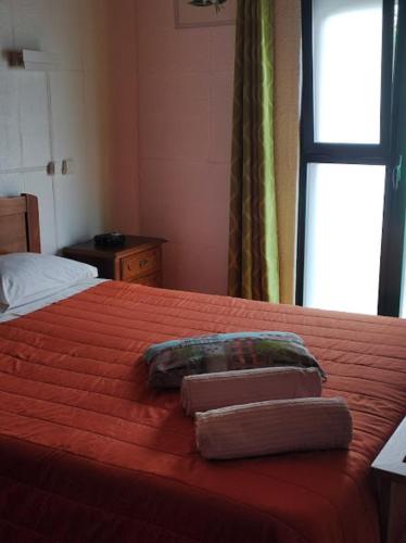 a bedroom with a bed with two towels on it at Apartamento Valados in Ponta Delgada