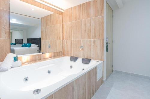 Hotel Urbano 70 في ميديلين: حمام مع حوض ومرآة كبيرة