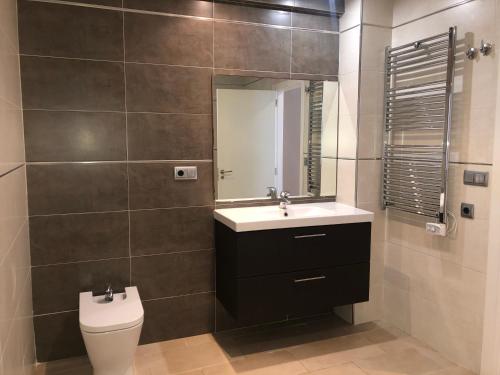 a bathroom with a toilet and a sink and a mirror at Acogedora casa en Cap Negret, ubicada a primera línea de la playa. in Altea