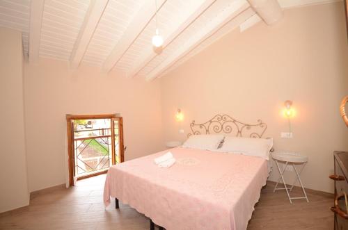 Habitación blanca con cama y ventana en Corte Vezzola bilocale Emma, en Puegnago sul Garda