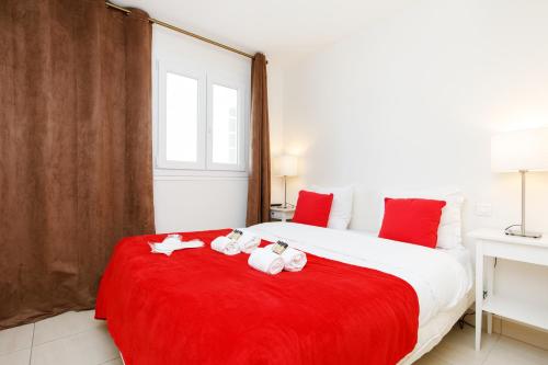 une chambre avec un grand lit blanc avec des oreillers rouges dans l'établissement Archer de Palma YourHostHelper, à Cannes