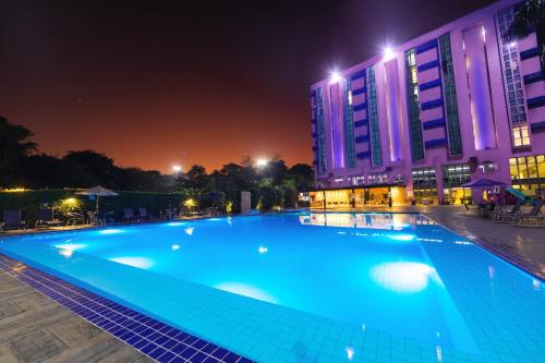 a large swimming pool at night with buildings at Falls Galli Hotel in Foz do Iguaçu