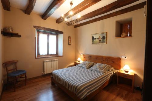 1 dormitorio con 1 cama, 1 silla y 1 ventana en Apaiolarre, en Zuaztoy de Azpilcueta