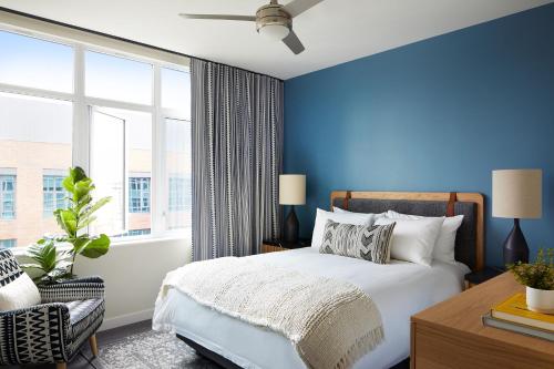 a blue bedroom with a bed and a window at Sentral Union Station in Denver