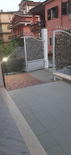 a white gate in front of a pink building at La Rosa Verde in Castrovillari