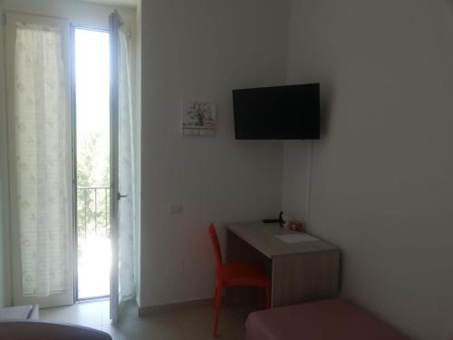 Pokój z biurkiem i telewizorem na ścianie w obiekcie Villa Maria Cristina d'Amico w mieście Cava deʼ Tirreni