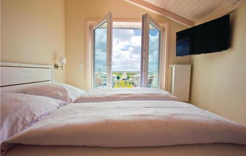 ダゲビュルにあるBeautiful Home In Dagebll With 3 Bedrooms, Sauna And Wifiの大きな窓付きの客室で、ベッド2台が備わります。