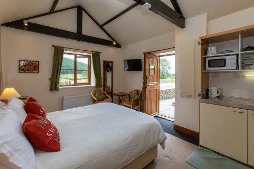 a bedroom with a large bed and a kitchen at Rawcliffe House Farm Studios, Peaceful North York Moors Retreat in Pickering