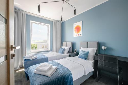 two beds in a room with blue walls at Apartament G312 Łódź Jana Matejki 11 in Łódź