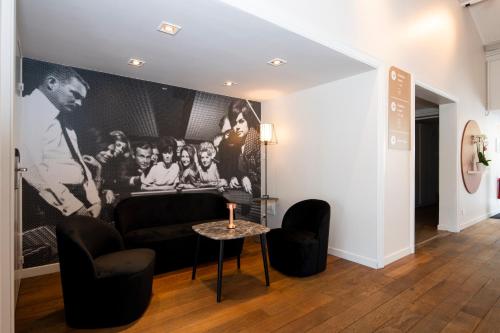 a living room with a couch and two chairs and a table at L'hôtel by JOA de Saint-Paul-Lès-Dax in Saint-Paul-lès-Dax