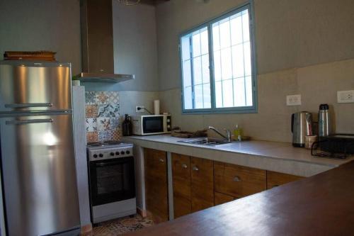 a kitchen with a stainless steel refrigerator and a sink at casa de campo :AHICITO in Ciudad Lujan de Cuyo
