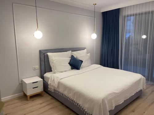 a bedroom with a bed with white sheets and pillows at Rezydencja Niechorze 108 Prestige in Niechorze