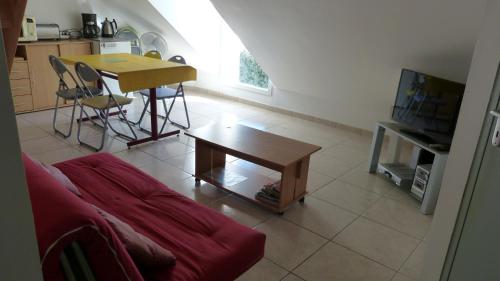 a living room with a red couch and a table at Residence des Ondines in Damgan