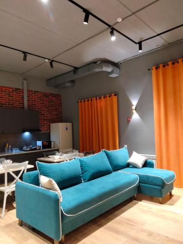 a blue couch in a living room with a table at Hostel Bro Astana in Astana