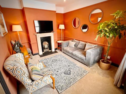 a living room with a couch and a fireplace at Unique & Stylish Town House, central Cheltenham in Cheltenham