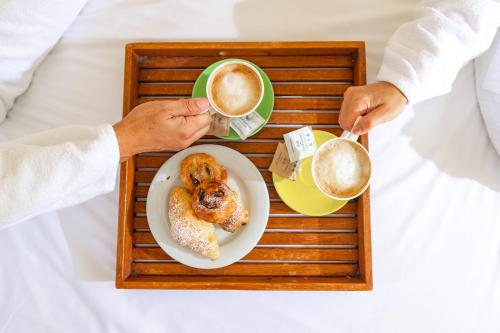 a tray with a plate of food and a cup of coffee at UNAHOTELS Club Hotel Ancora in Stintino